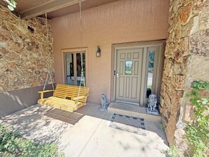 A stone exterior with a wooden bench and a door.
