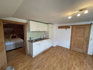 A compact kitchen with white cabinets, a wooden countertop, and a built-in sink. - Seebichlhof 3 - Streif (Kitzbühel)