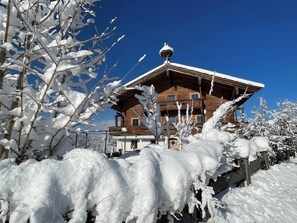 A wooden chalet with a balcony, surrounded by snow-covered trees. - Seebichlhof 3 - Streif (Kitzbühel)