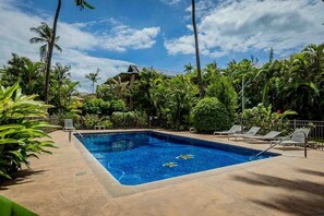 A rectangular swimming pool surrounded by palm trees and lounge chairs. - Kalama Terrace L203 2 Bedroom Apts (Kihei)