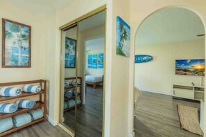 A hotel room with a wooden floor, a bed, a wardrobe, and a large mirror. - Kalama Terrace L203 2 Bedroom Apts (Kihei)