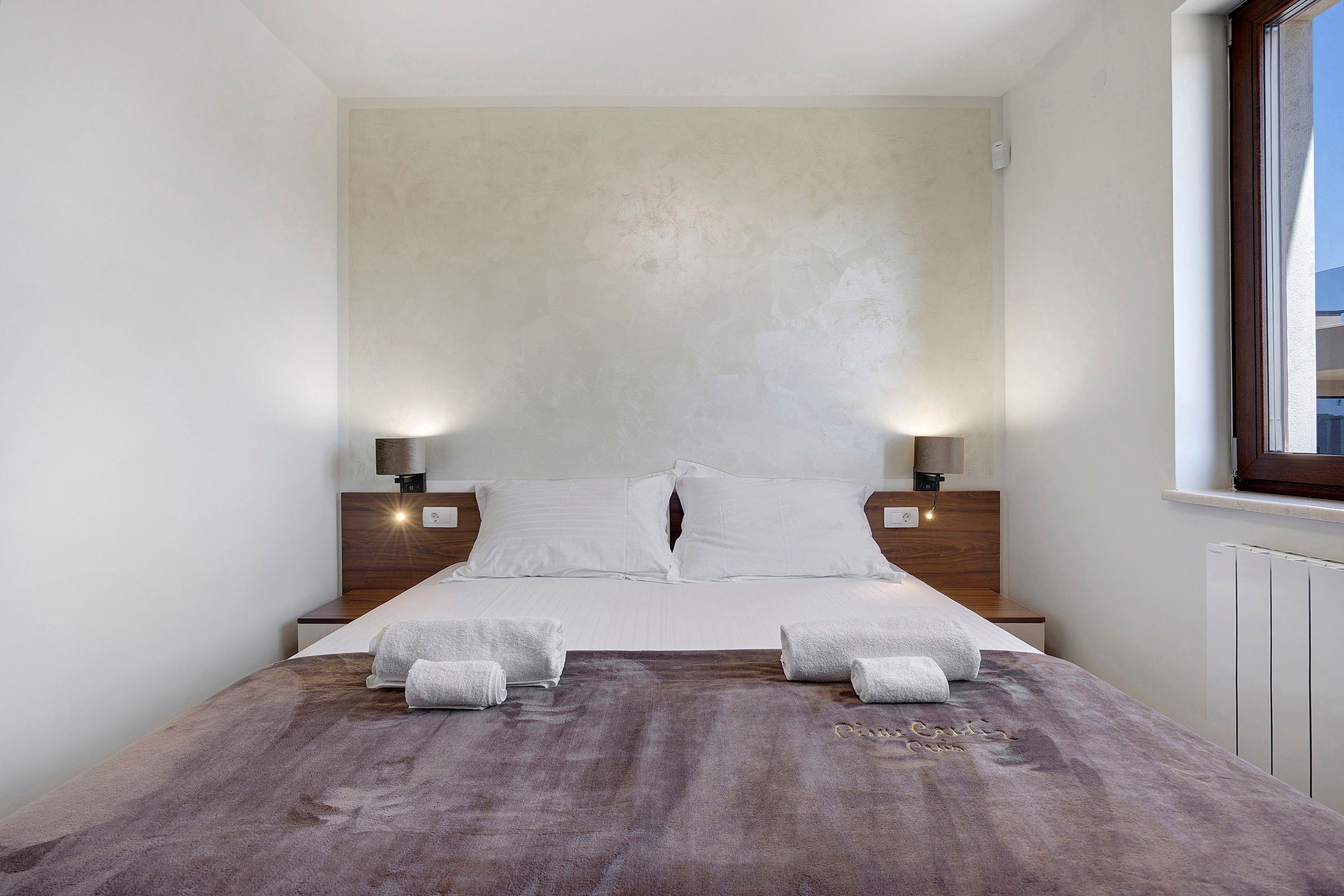Una camera da letto con un letto grande, due comodini e una finestra.