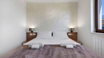Una camera da letto con un letto grande, due comodini e una finestra.