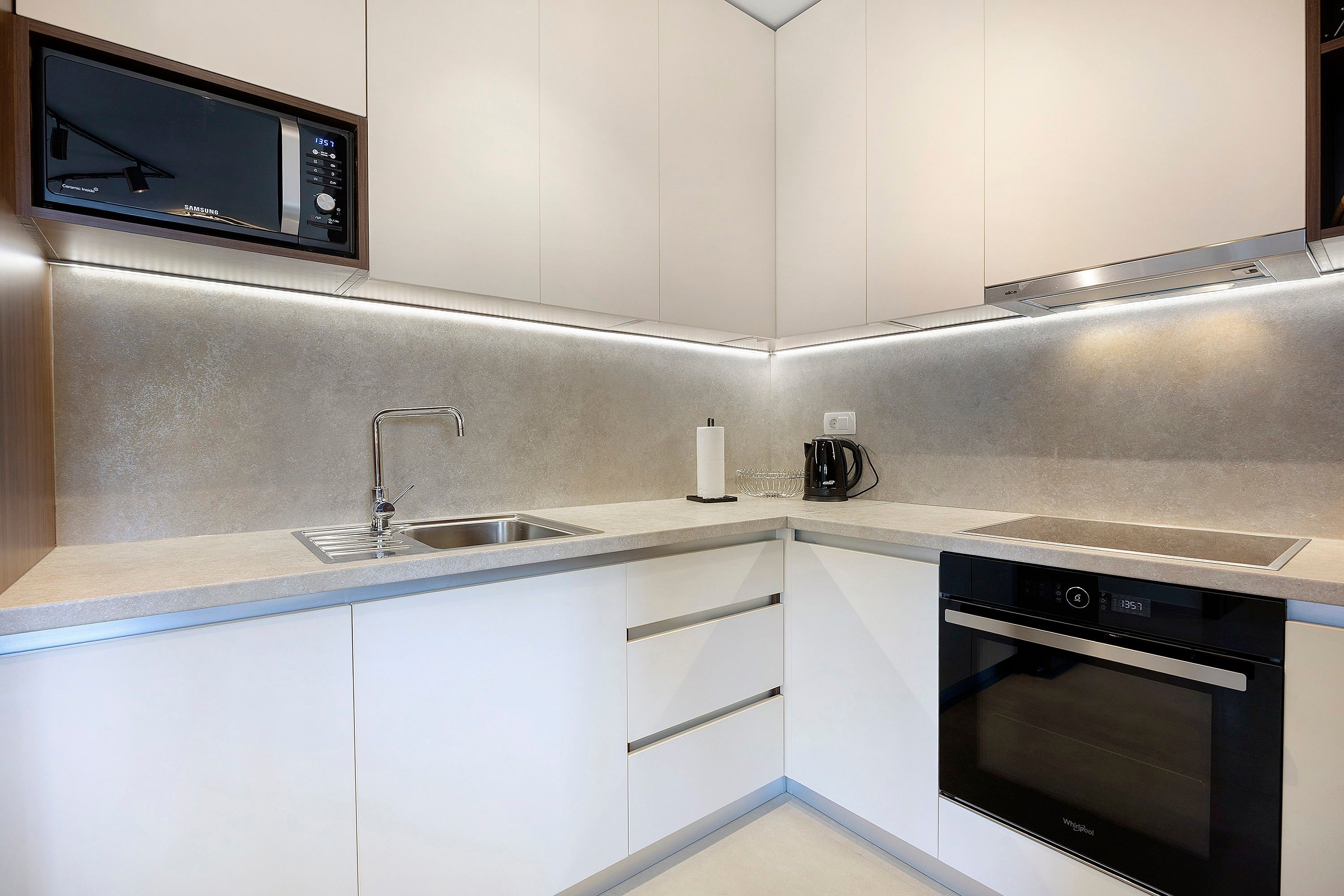A compact kitchen with a microwave, coffee maker, and dishwasher.