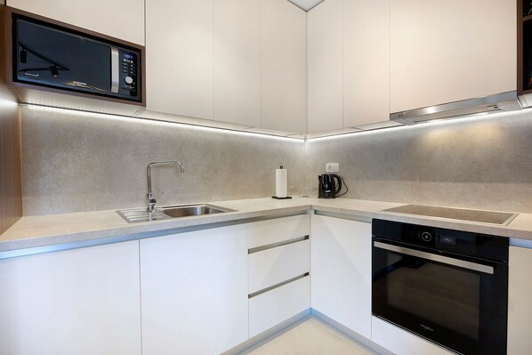 A compact kitchen with a microwave, coffee maker, and dishwasher.