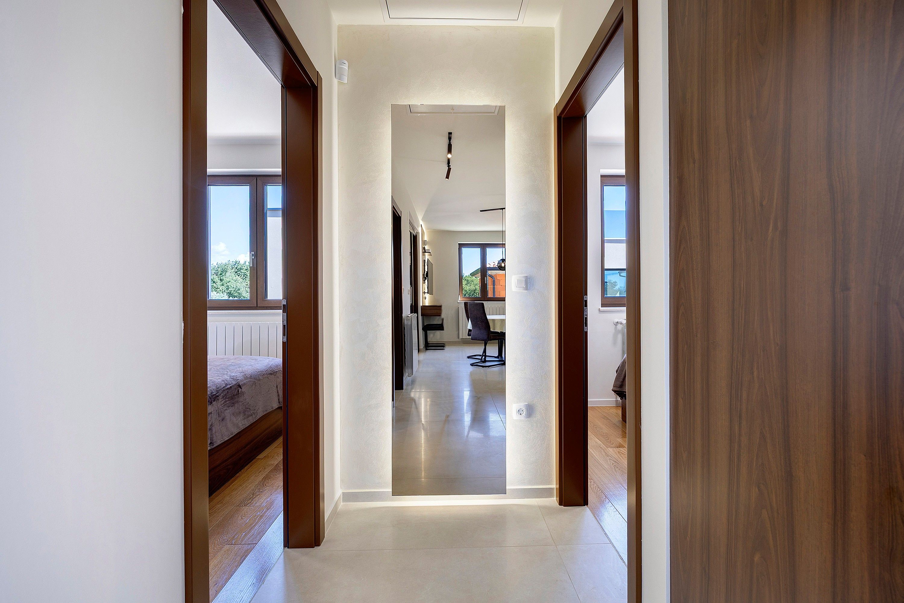 A hallway with a bed, a radiator, and a chair.