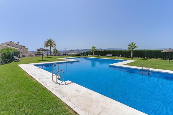 A swimming pool with a clear view of the surrounding landscape, including a mountain range in the distance.