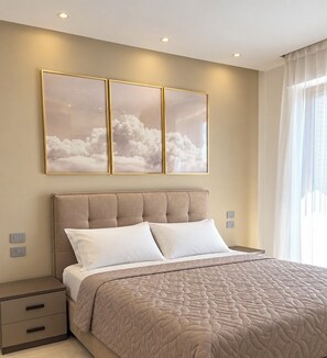 Ein Schlafzimmer mit Bett, Nachttischen, einem Kopfteil und Wandbildern.