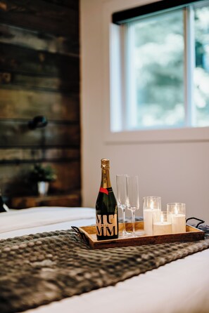 A bed with a bottle of Mumm Napa Brut champagne, glasses, and candles on a tray. - Le Doux Boisé - Beach Access - 15 min. from Mont Tremblant   (LA CONCEPTION)