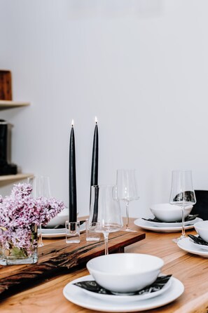 Une table à manger dressée avec des bougies, des verres et un saladier.