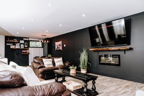 Una sala de estar moderna con un sofá de cuero, una mesita de centro y un televisor de pantalla plana montado en la pared.