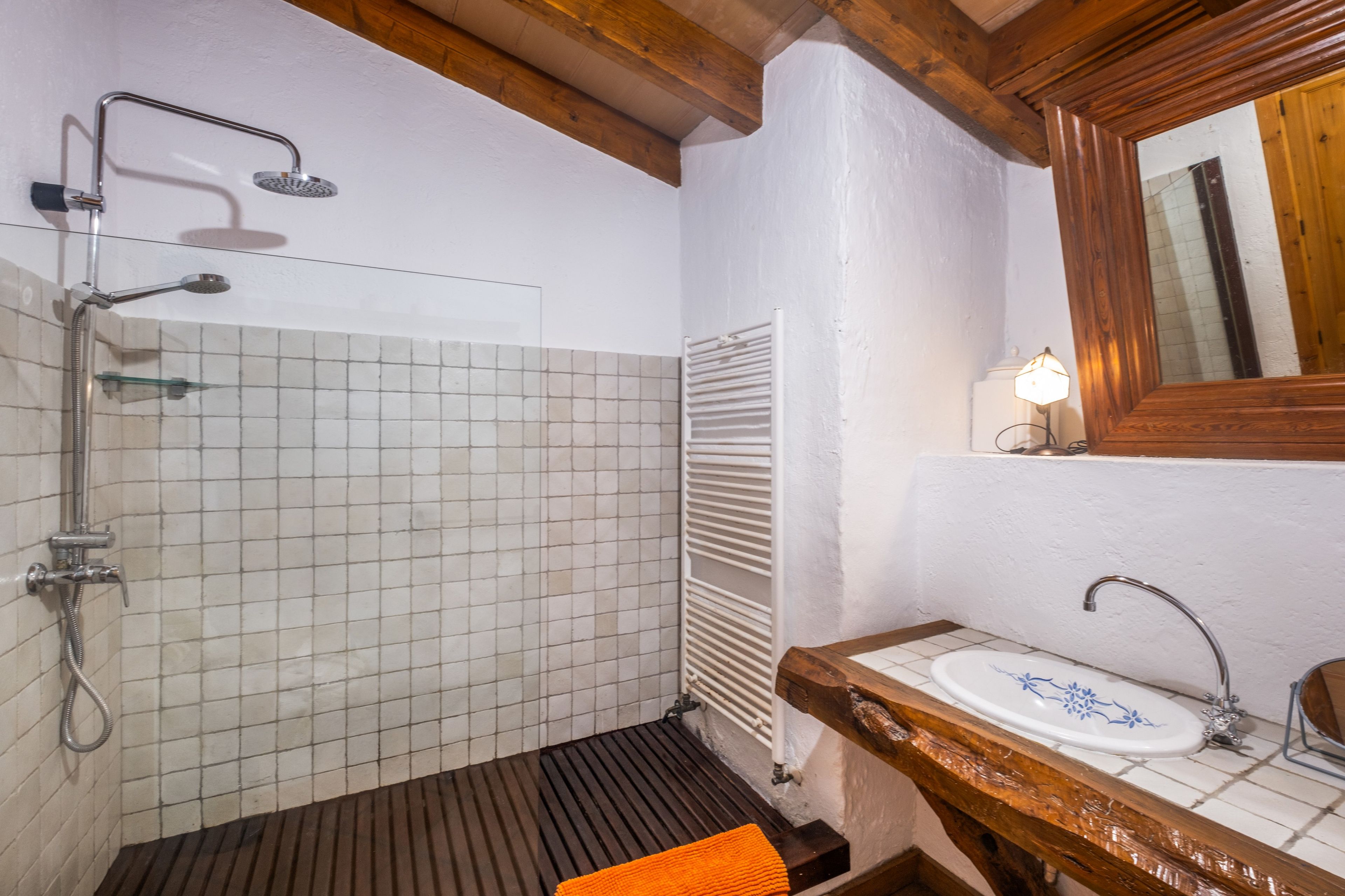 A bathroom with a shower, a sink, and a mirror.
