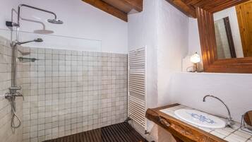 A bathroom with a shower, a sink, and a mirror.