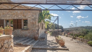 A stone building with a wooden staircase leading to a covered area.