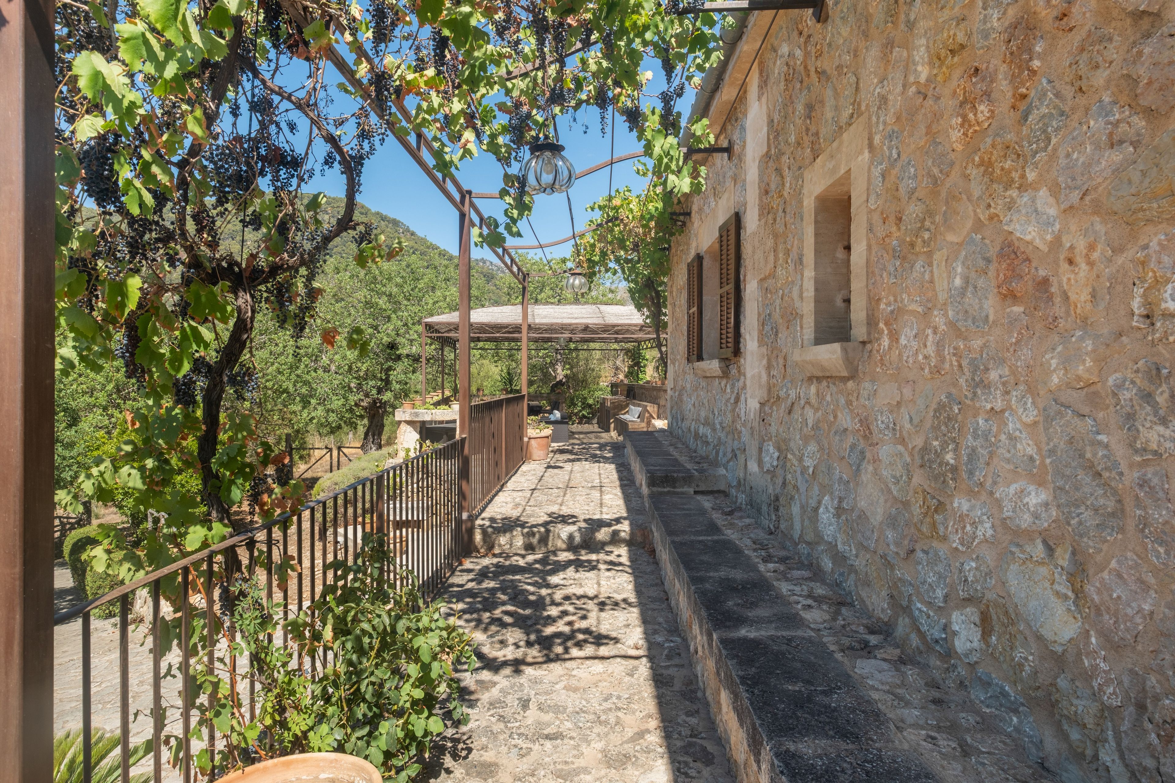 A stone building with a narrow pathway leading to a covered area.