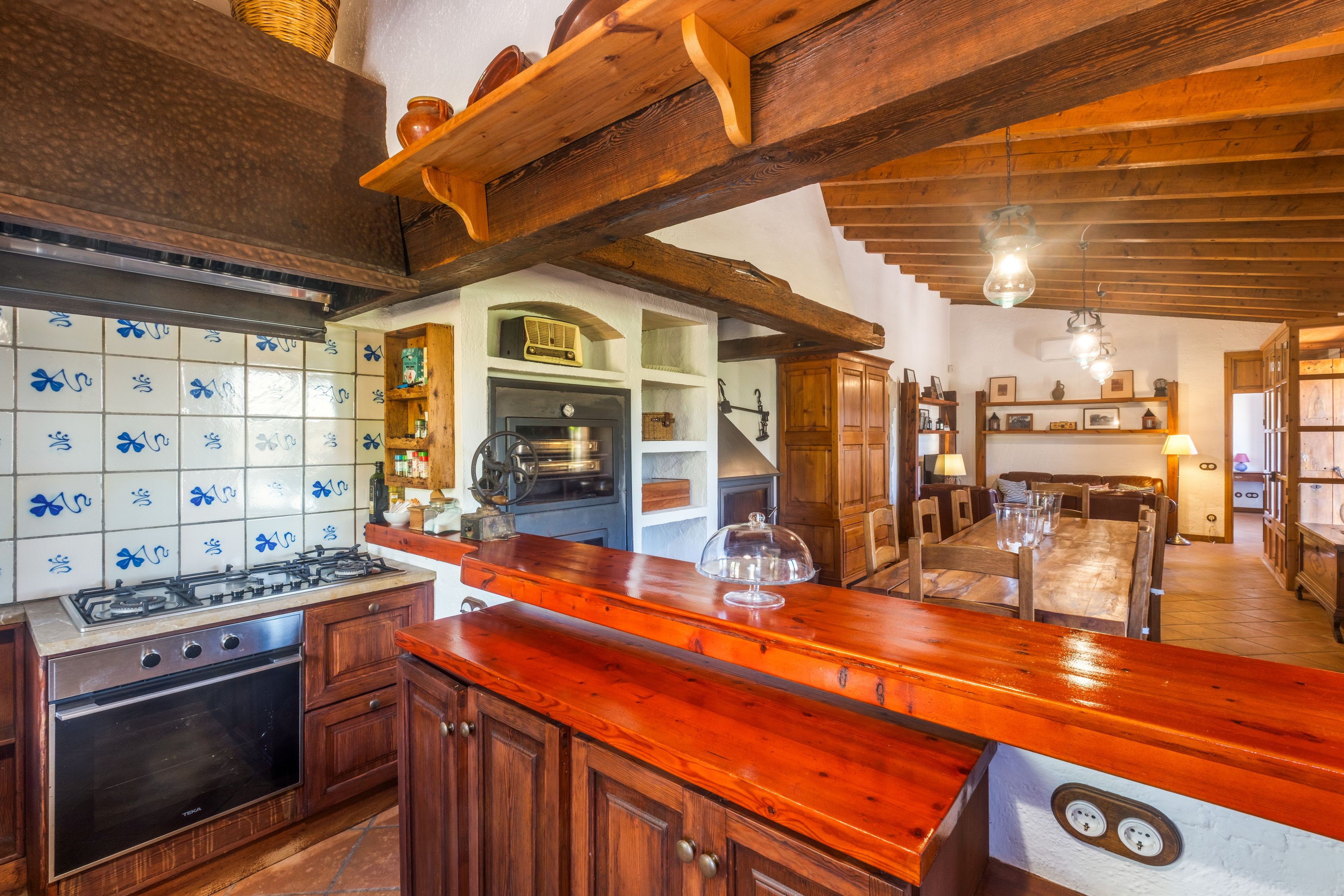 A kitchen with wooden cabinets, a stove, and a tiled backsplash.