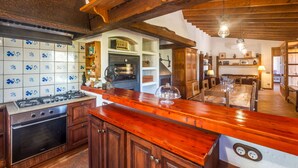 A kitchen with wooden cabinets, a stove, and a tiled backsplash.