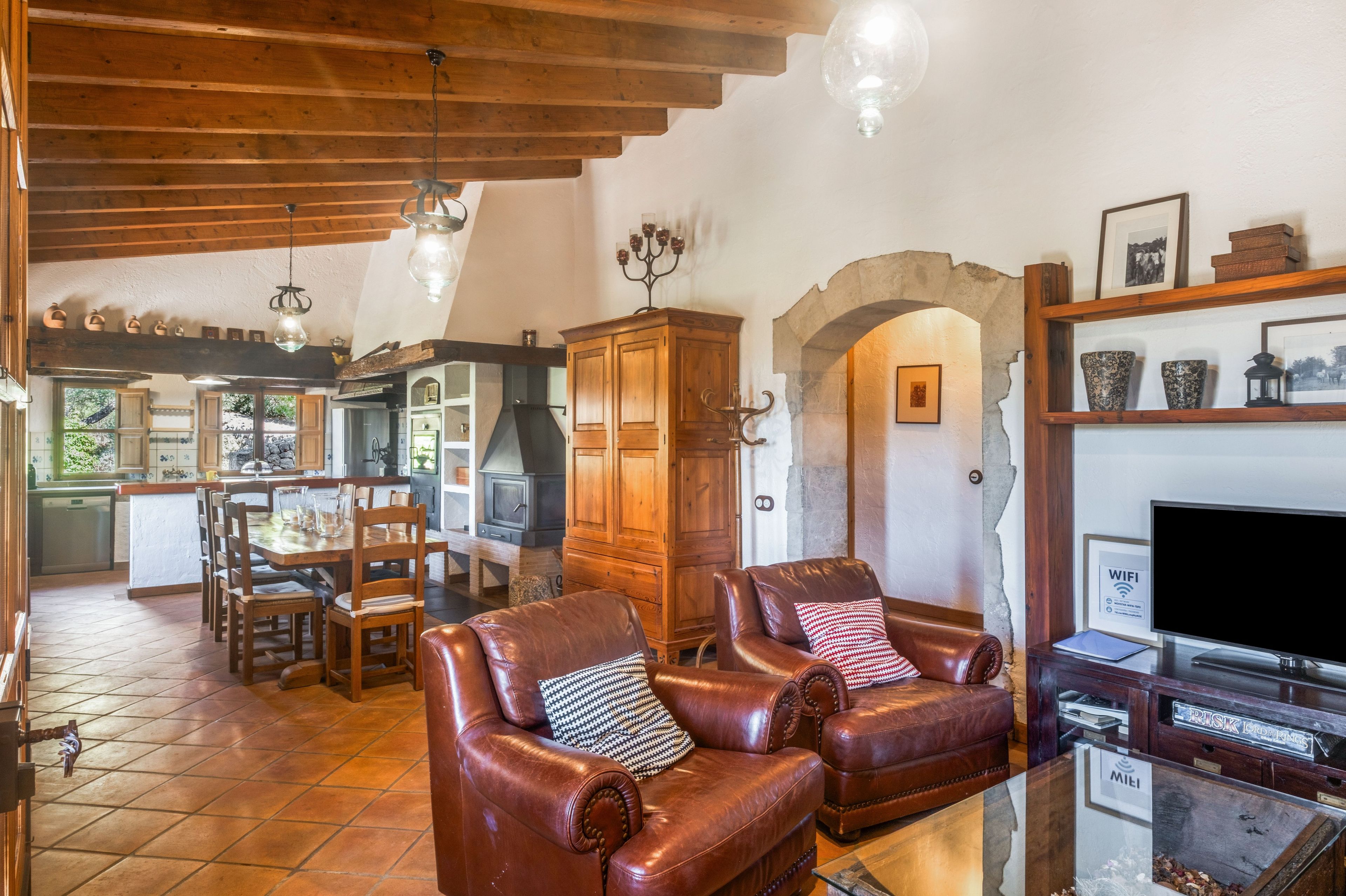 A cozy living room with leather sofas, a fireplace, and a television.
