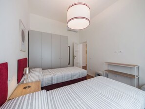 A bedroom with two beds, a wardrobe, a desk, and a hanging light fixture. - Beautiful  villa for 5 people with WIFI, A/C, TV and patio (Viareggio)
