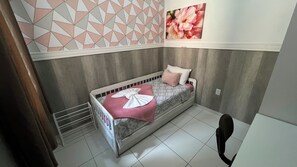 Un dormitorio pequeño y ordenado con una cama individual, una obra de arte colgada en la pared y un radiador.