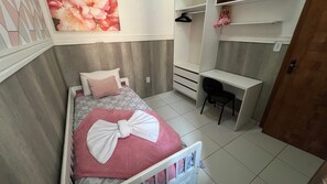 Ein Schlafzimmer mit einem Bett, einem Schreibtisch und einer Kommode.
