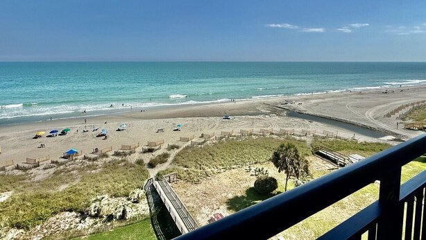 A beach with a clear view of the ocean, a sandy beach, and a wooden boardwalk leading to the water. - Oceanfront 1BR Sleeps 4-6 Myrtle Beach 421 (Myrtle Beach)