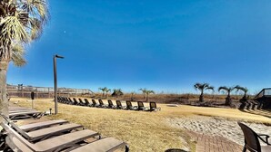 A sunlit outdoor seating area with lounge chairs and a paved walkway. - Oceanfront 1BR Sleeps 4-6 Myrtle Beach 421 (Myrtle Beach)