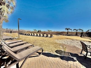 A sunlit outdoor seating area with lounge chairs and a paved walkway. - Oceanfront 1BR Sleeps 4-6 Myrtle Beach 421 (Myrtle Beach)
