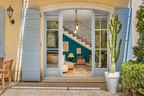 A curved entrance with a staircase leading to a living area with a sofa and a lamp. - Villa Jasmin | French Riviera Retreat (Vence)