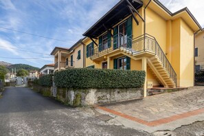 Ein gelbes Gebäude mit Treppe und Balkon.