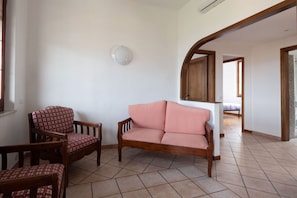 A living room with a sofa, chairs, and a wall-mounted light fixture. - [Appartamento Roberta] 5 beds + A/C (Santo Stefano di Magra)