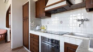 A kitchen with wooden cabinets, a stainless steel oven, and a white tiled backsplash.
