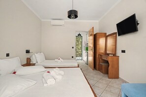 Een hotelkamer met twee bedden, een bureau, een televisie en een airconditioning.
