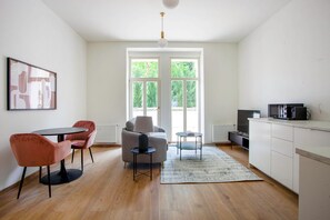 A modern kitchen with a dining area, a sofa, and a coffee table. - Blueground Grebovka, Terrace, pet Friendly (Prague)