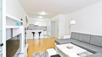 Un appartement moderne comprenant une cuisine, un coin repas et un salon.