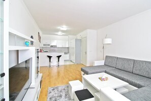A modern apartment with a kitchen, dining area, and living room.