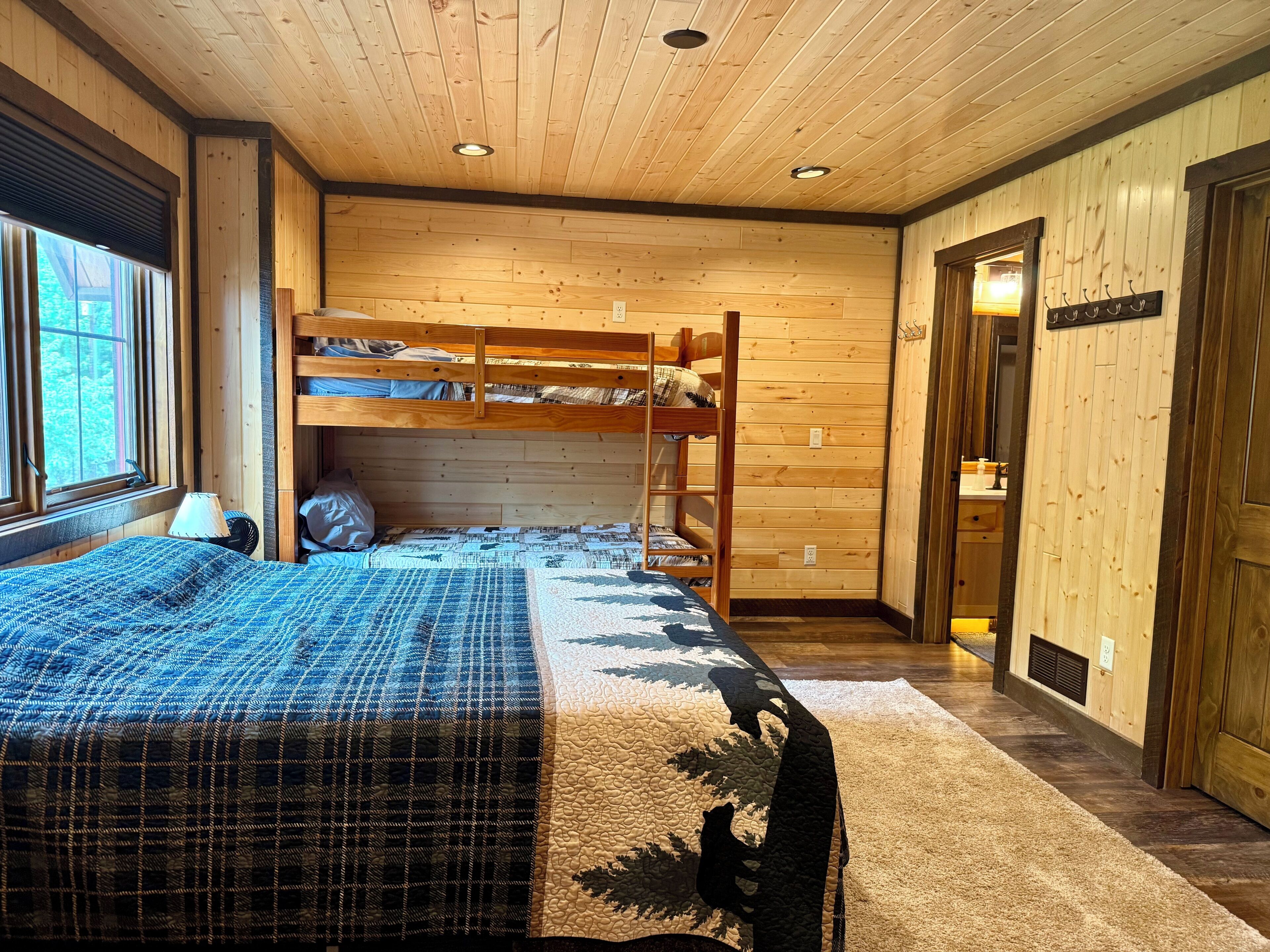 Une chambre avec un lit superposé, un bureau et une fenêtre.