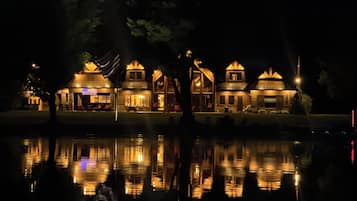 A waterfront property with multiple buildings, a reflective water surface, and a flag.