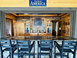 A bar area with a wooden theme, including a sign that reads 'God Bless America.'
