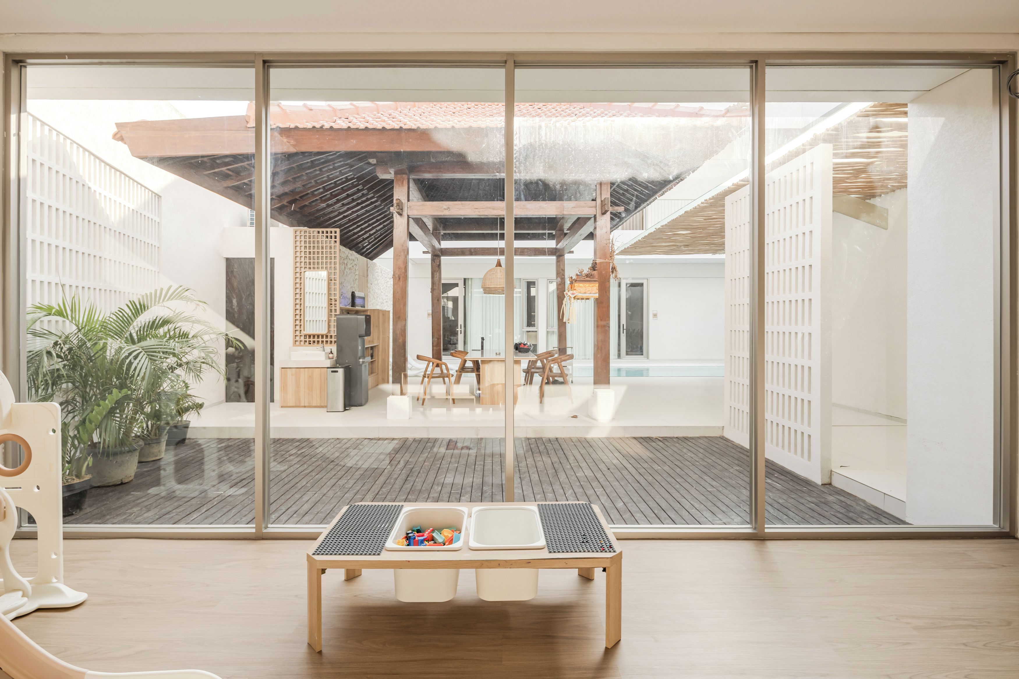 Un intérieur moderne avec une grande porte-fenêtre coulissante donnant sur un patio extérieur.