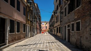 A narrow cobblestone street flanked by historic buildings with multiple stories and balconies. - Suite Mondrian 100m from Biennale - Canal View (Venezia)