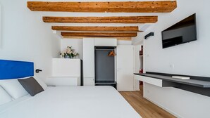 A modern bedroom with a bed, a TV, and a kitchenette. - Suite Mondrian 100m from Biennale - Canal View (Venezia)