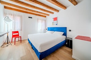 A room with a bed, a desk, a chair, and a window with curtains. - Suite Mondrian 100m from Biennale - Canal View (Venezia)