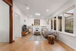 A spacious living room with a fireplace, a television, and a large window with a view.