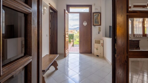 A hallway with a wooden bench, a door leading outside, and a small cabinet. - [Appartamento Roberto] 4 beds + A/C (Santo Stefano di Magra)