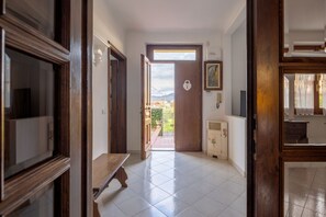 A hallway with a wooden bench, a door leading outside, and a small cabinet. - [Appartamento Roberto] 4 beds + A/C (Santo Stefano di Magra)