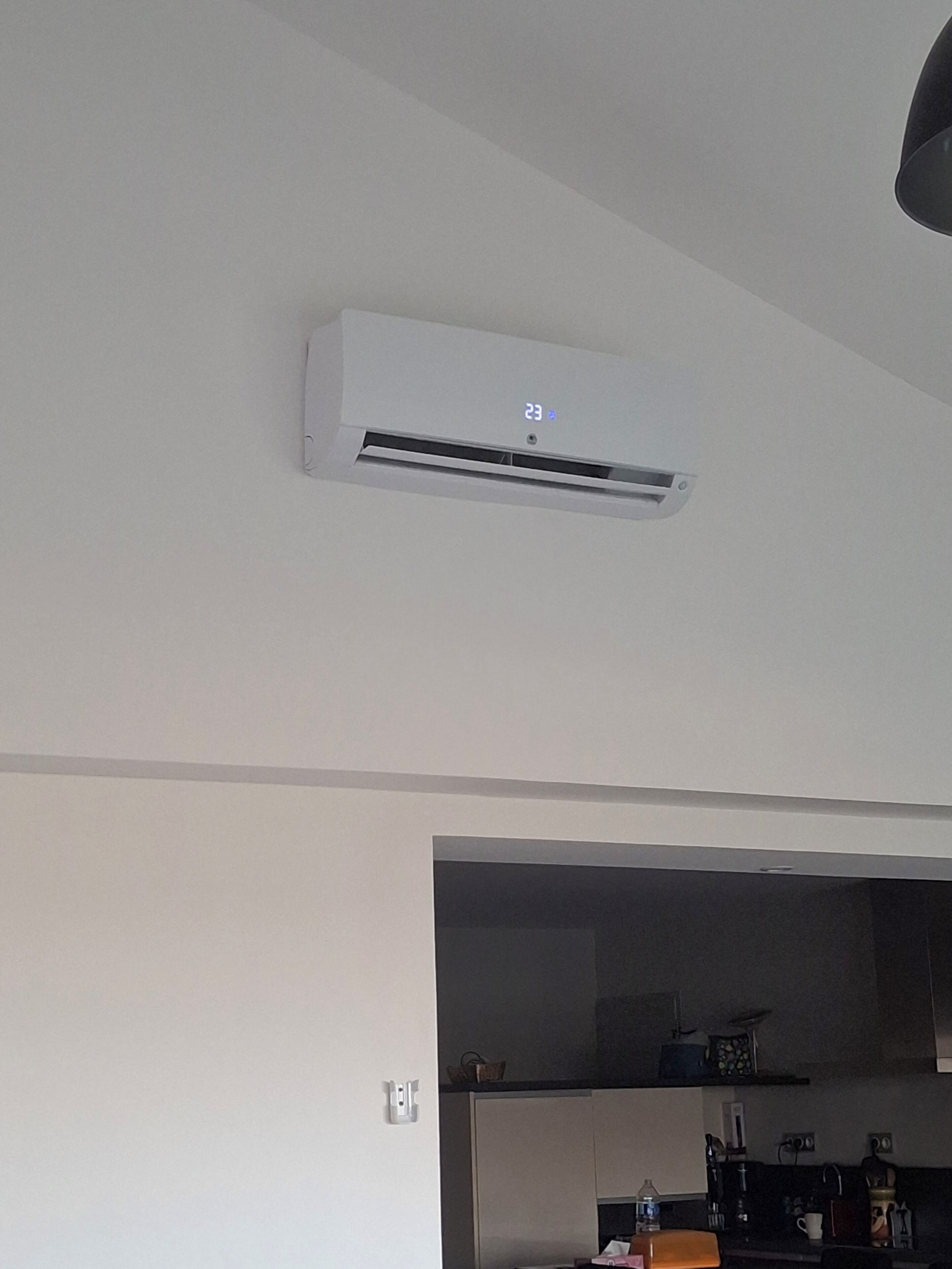 A kitchen with a built-in air conditioning unit and a water dispenser.