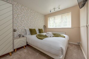 A bedroom with a bed, a wardrobe, a radiator, a window with blinds, and a ceiling light fixture. - Spacious 3-Bed Home in Wellington | Sleeps 5 - Pass the Keys (Telford)