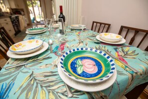 A dining table set with colorful plates, cutlery, and a bottle of wine. - Large Family House close to Cathedral Quarter - Pass the Keys (Lincoln)