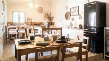 Une cuisine avec des meubles en bois, un réfrigérateur noir et divers ustensiles de cuisine disposés sur le plan de travail.